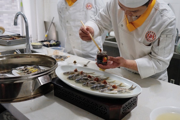 桌子上的碗里有一些人在廚房里做食物

描述已自動生成
